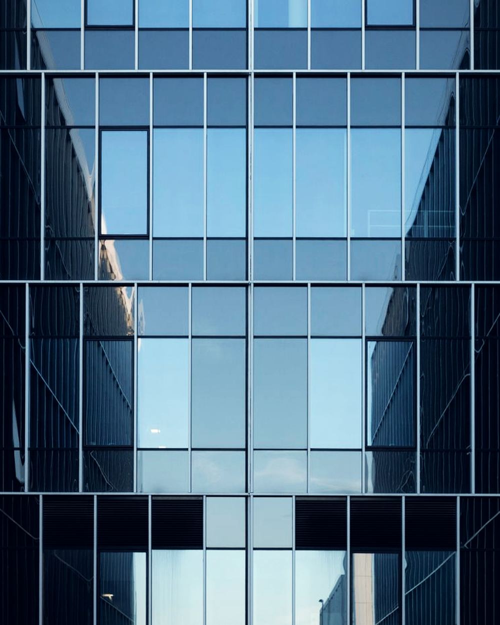 The glazed atrium of a commercial building, seen from below.