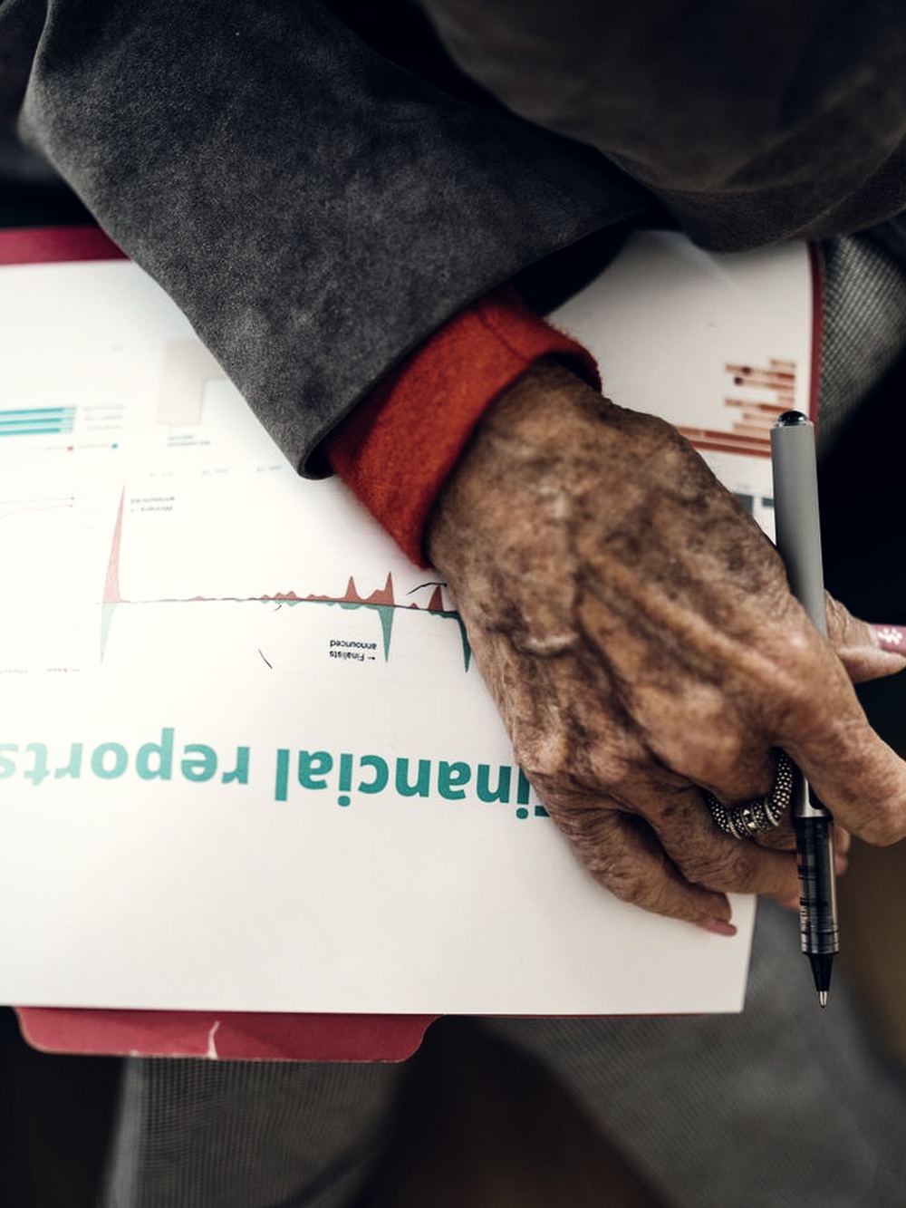 Hands reviewing a printed financial report.